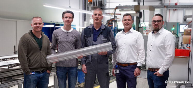 The Masterflex SE development team, segment leader and managing director jointly present the new Master-PUR DualFlow Food spiral hose with thermoplastic inner lining.