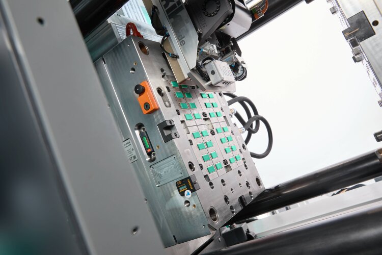 After a linear Multilift V 30 has placed 32 dominoes on a conveyor belt, a cobot takes over the subsequent packaging of the complete ready-to-use set of dominoes.
